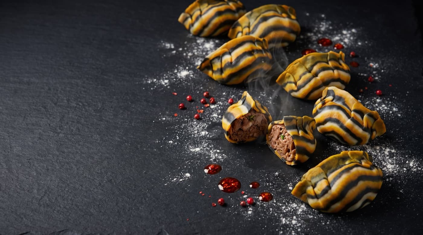 Tiger-striped dumplings, one cut open to show the meat filling